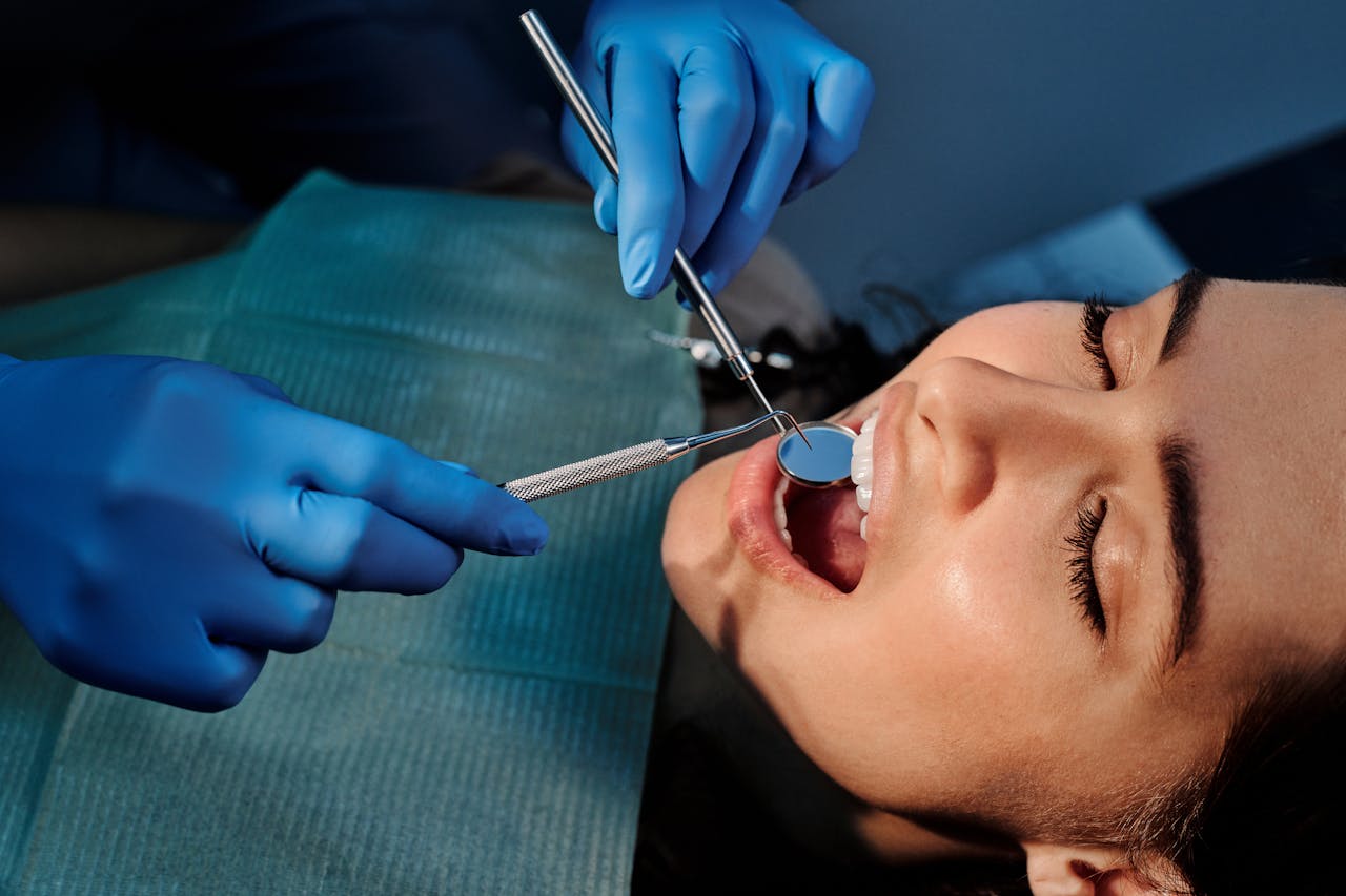 Close-up of a dentist examining a patient's teeth using dental tools.